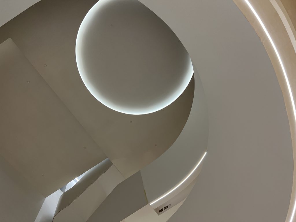 White curved walls, as viewed looking up.