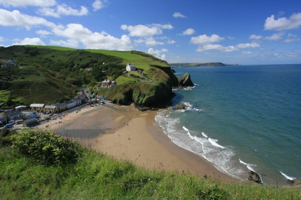 yellow sandy beach and sea and cliffs in Wales