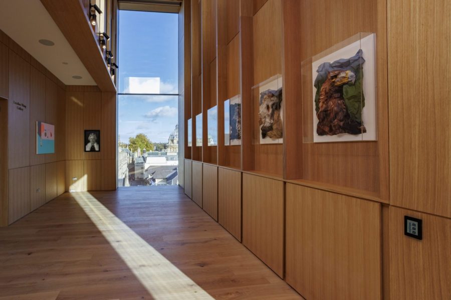 Looking down an oak panelled room towards a large glass window, with six perspex framed images of birds on right hand wall