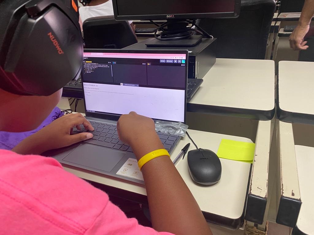 Editorial: Young person wears headphones and concentrates on laptop screen, seated at a desk