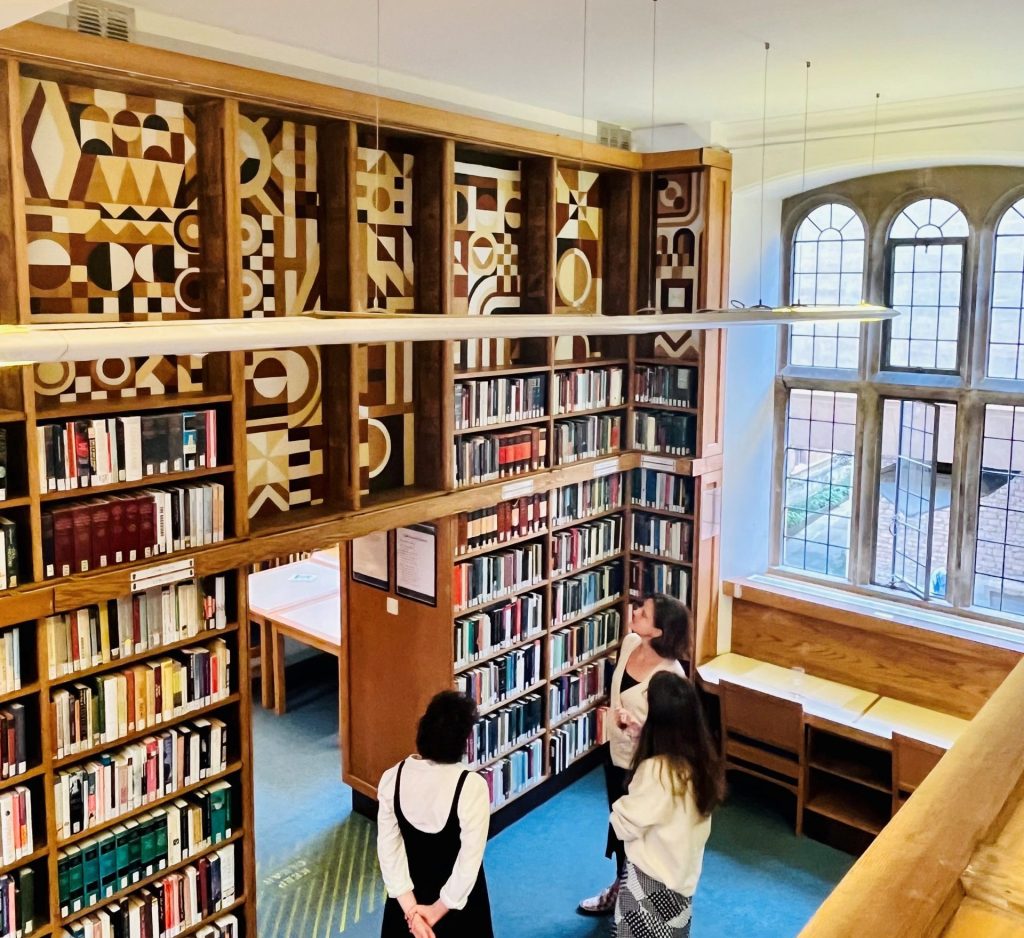 Large wall of book cases with geometirc design above