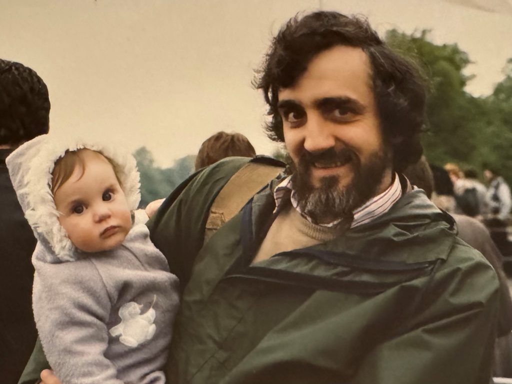 Man with beard holds baby.