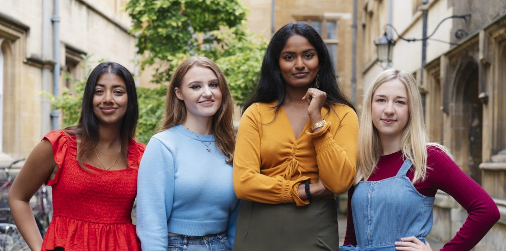 Four young women standing in the Third Quad at Jesus College.